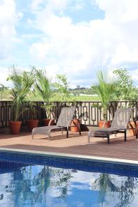 a pair of chairs sitting next to a swimming pool at Pouso Mineiro in São João Batista do Glória