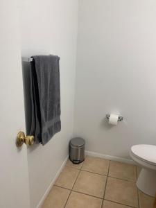 La salle de bains est pourvue de toilettes et d'une serviette sur la porte. dans l'établissement Sweet Home IN, à Indianapolis