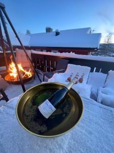 a bottle of wine in a bowl next to a fire at Villa Solsiden Geilo in Geilo
