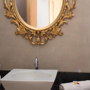 uma casa de banho com um lavatório e um espelho na parede em Pouso Mineiro em São João Batista do Glória