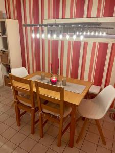 uma mesa de jantar com cadeiras e uma vela em Schönes und ruhiges Privatzimmer mit französischem Balkon em Munique