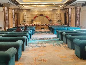 una fila di sedie blu in una stanza grande di Four Leaf Hotel - AKOSHA 