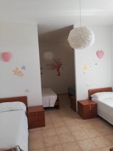 Habitación con 2 camas con corazones en las paredes. en Marrubiu Resort Note di Stelle, en Marrùbiu