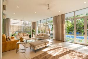 a living room with a lot of windows at EKOSTAY Luxe I Avante Villa in Calangute