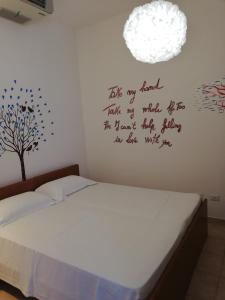 a bedroom with a bed with a tree on the wall at Marrubiu Resort Note di Stelle in Marrùbiu