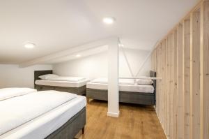 two beds in a room with wooden walls at Baza Sopot in Sopot