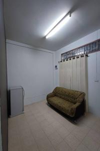een woonkamer met een bank in een kamer bij Andaman Residence in Thalang