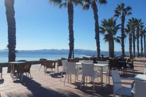 Rodaにある3 Bed Apartment Sleeps 6 with Shared Poolのヤシの木が植えられたパティオ(テーブル、椅子付)