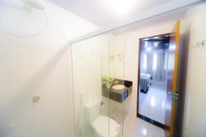 a bathroom with a toilet and a glass shower at Pousada Toca dos Aventureiros in Barreirinhas