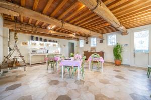 uma sala de jantar com mesas e cadeiras cor-de-rosa em Soave Country House em Angiari