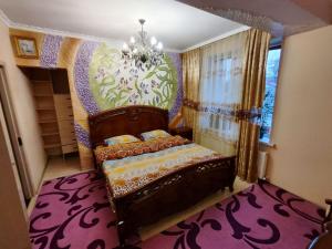 Un dormitorio con una cama y una lámpara de araña. en Gold Rose Apartament, en Chişinău