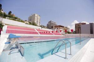 a large swimming pool with red seats in a city at Three Bedroom Romantic Promenade Apartment in Durrës
