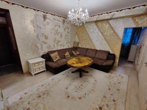 uma sala de estar com um sofá e uma mesa em Gold Rose Apartament em Chisinau