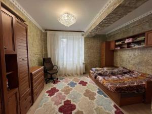 um quarto com uma cama, uma secretária e uma cadeira em Gold Rose Apartament em Chisinau