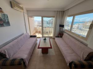 ein Wohnzimmer mit einem großen Sofa und einem Tisch in der Unterkunft HOLIDAY APART 50 meters to BEACH, Sea view apartments in Didim