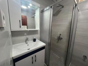 een badkamer met een wastafel en een douche bij HOLIDAY APART 50 meters to BEACH, Sea view apartments in Didim