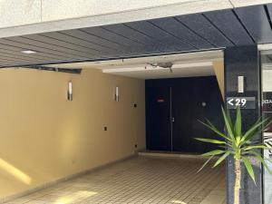 un pasillo con una puerta negra y una planta en Motel Flamingo en Perafita