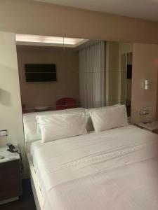 1 dormitorio con 2 camas con sábanas y almohadas blancas en Motel Flamingo, en Perafita