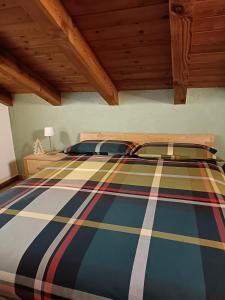 una camera da letto con un letto con un piumone a righe di La Sarrolein CIR 0009 ad Aosta