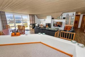 uma ampla sala de estar com uma cozinha e uma sala de estar em Charming thatched stone house by the sea - SJ241 em Harboør