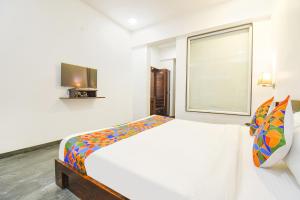 a white room with a bed and a window at FabHotel Prime Kantara in Lonavala
