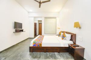 a bedroom with a large bed and a tv at FabHotel Prime Kantara in Lonavala