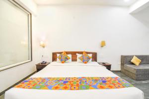 a bedroom with a large bed with a colorful blanket at FabHotel Prime Kantara in Lonavala