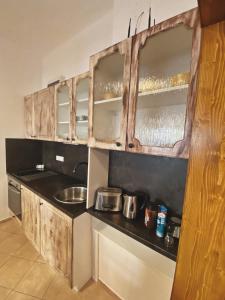 cocina con armarios de madera y encimera en Apartmán Sirius B en České Budějovice