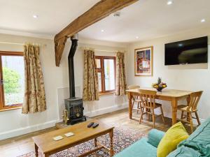 a living room with a wood stove and a table at Walnut Cottage - Horsham in Horsham