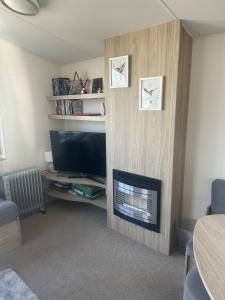a living room with a fireplace and a tv at Shells Breaks Tattershall Lakes Shearwater 27 in Tattershall