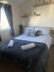 1 dormitorio con 1 cama con toallas en Shells Breaks Tattershall Lakes Shearwater 27, en Tattershall