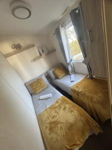 a small room with two beds and a window at Shells Breaks Tattershall Lakes Shearwater 27 in Tattershall