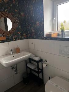 uma casa de banho com um lavatório e um WC em Casalino em Wachtendonk
