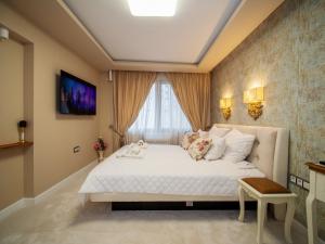 a bedroom with a large white bed in front of a window at Paradise Center Premium Suite 1 in Sofia