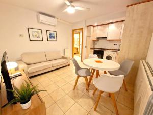 a kitchen and living room with a table and chairs at Sierco Apartamentos Ainsa in Aínsa