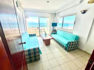 ein Wohnzimmer mit Couch und Blick aufs Meer in der Unterkunft HOLIDAY APART 50 meters to BEACH, Sea view apartments in Didim