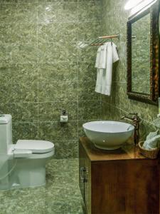 a bathroom with a sink and a toilet and a mirror at Buudai hotel in Darkhan