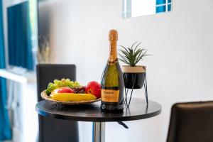 a bottle of wine and a basket of fruit on a table at City Centre Apartment - Balcony - Netflix - Park Facing 38AKW in Birmingham +10 photos
