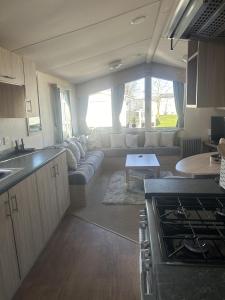 a kitchen and a living room with a couch at Shells Breaks Tattershall Lakes Shearwater 27 in Tattershall