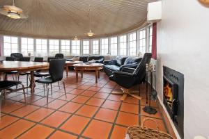 uma sala de estar com um sofá e mesas e uma lareira em Thatched house with pool by the sea - SJ690 em Harboør