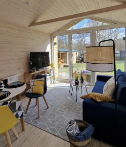 a living room with a blue couch and a tv at Tiny House Lotta in Stuer