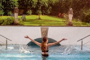 une femme debout dans l'eau dans un bassin dans l'établissement Burleigh Court Hotel, à Stroud