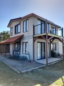 波特苏埃洛Aroma de mar casas en alquiler vacacional con hermosa piscina的有黑色窗户的白色房子