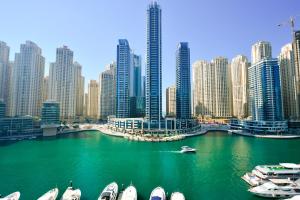 a group of boats in a river in a city at InterContinental Dubai Marina by IHG in Dubai