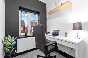a desk with a chair in a room with a window at Luxury by the Sea, Beautiful 3 bedroom House with Fast WiFi, King Bed, Lovely Garden! Blackpool's Finest Getaway Experience for up to 8 Guests! in Blackpool