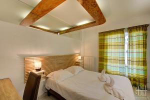 1 dormitorio con cama blanca y ventana en Sourdillon/Hôpital Clocheville, en Tours
