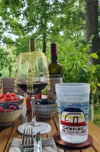uma garrafa de vinho e um copo sobre uma mesa em Tiny House Lotta em Stuer