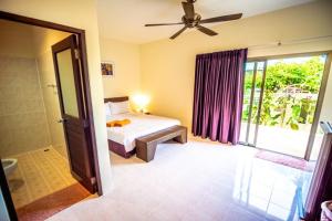 a bedroom with a bed and a sliding glass door at Muchshima House in Bang Tao Beach