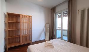 1 dormitorio con cama, estante de libros y ventana en Suite Lotus Senna, en Milán