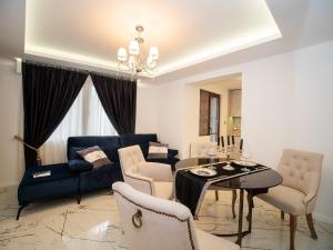 a living room with a blue couch and a table at Paradise Center Premium Suite 2 in Sofia